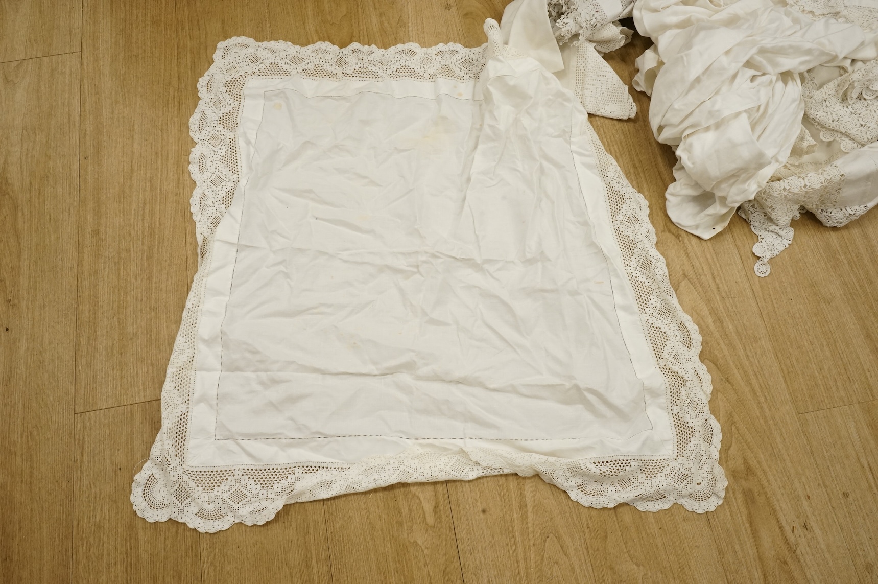 A collection of crochet, embroidered and damask linen table cloths and napkins
